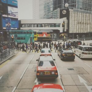 Busy city intersection in Central Hong Kong with pedestrians and traffic, capturing urban life.